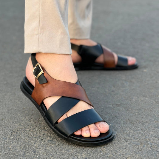  black and brown cross-stitched sandals with a textured strip on the sole.
