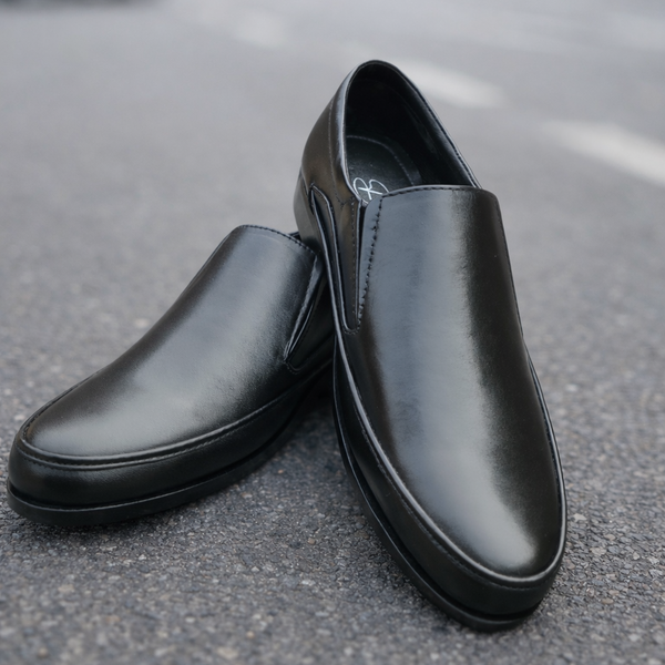 Black leather shoes on a road with a blurred background